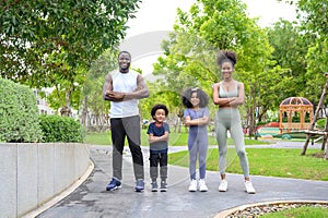 Portrait of Happy African American smiling family resting and having fun after workout outdoors, wearing sports clothes. father,