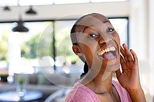 Portrait of happy african american woman looking at camera and smiling at home