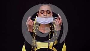 Portrait of happy african american woman with medical mask. Girl with afro hair style. Braids with yellow kanekalon