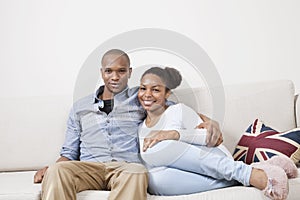 Portrait of happy African American young couple relaxing on sofa