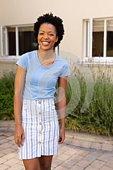 Portrait of happy african american young woman smiling while standing outdoors