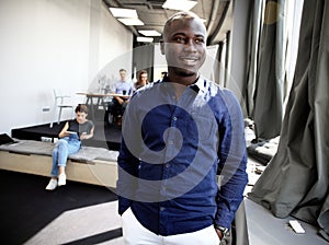 Portrait of happy African guy looking at camera in working environment.