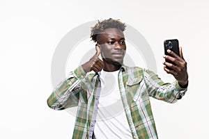 Portrait of a happy african man taking selfie standing isolated over white background