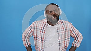 Portrait of happy afroamerican man listen to music on headphones and dance 4K