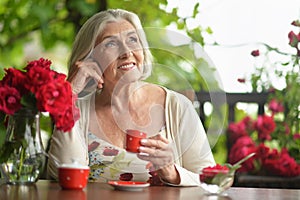 Portrait of a happy aged woman drinking coffee