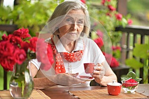 Portrait of a happy aged woman drinking coffee