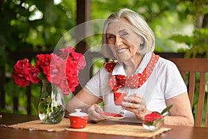 Portrait of a happy aged woman drinking coffee