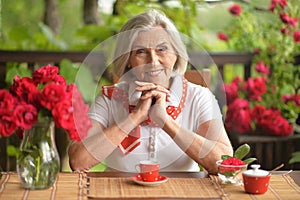 Portrait of a happy aged woman drinking coffee