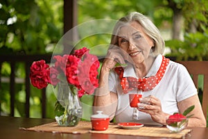 Portrait of a happy aged woman drinking coffee