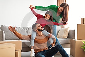 Portrait of happy Arab family having fun at new home