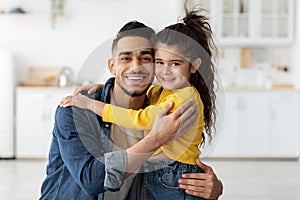 Portrait Of Happy Arab Father And Cute Little Daughter Embracing At Home