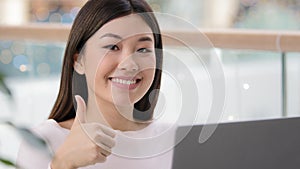 Portrait happy asian business woman portrait posing workplace showing cool thumb up gesture smiling agree super good