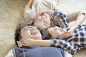 Portrait Happy Asian Family laying down and playing in living room.