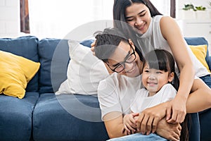 Portrait of happy Asian family spending time together on sofa in living room. family and home concept.