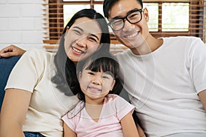 Portrait of happy Asian family spending time together on sofa in living room. family and home concept.