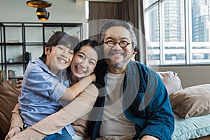 Portrait of happy Asian family spending time together on sofa in living room. family and home concept.