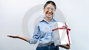 Portrait of happy asian girl holding present box while standing