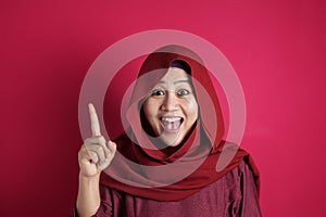 Muslim Woman Having Bright Idea, Looking at Camera Smiling and Pointing Up