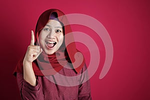 Muslim Woman Having Bright Idea, Looking at Camera Smiling and Pointing Up