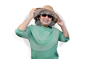 Portrait of happy asian senior woman wearing sunglasses and a hat standing isolated on white background. Concept of tourist enjoy