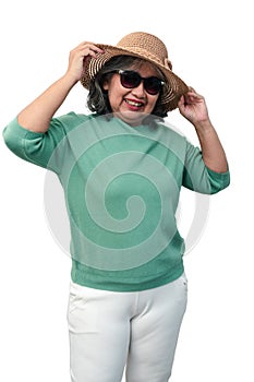 Portrait of happy asian senior woman wearing sunglasses and a hat standing isolated on white background. Concept of tourist enjoy