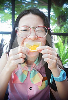 Portrait of happy asian woman in a cafe with mandlin orange against of a mouth like a smile,say cheese concept,happy with food