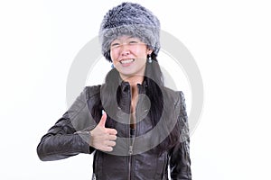 Portrait of happy Asian woman giving thumbs up ready for winter