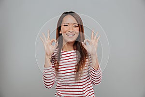 Portrait of a happy asian woman showing ok gesture