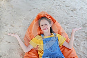 Portrait of happy Asian young girl child in dungarees jean open hands wide or spread your arms and looking camera while relax on