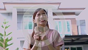 Portrait of happy attractive Asian women holding a lot of banknotes in front of home to celebrate and Pay the final installment of