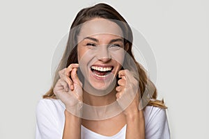 Portrait happy attractive woman cleaning teeth with dental floss