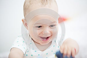 Portrait of a happy baby boy playing on floor in children& x27;s room