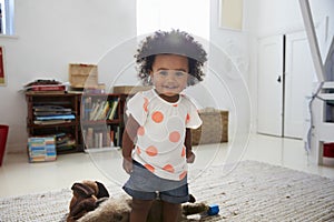 Portrait Of Happy Baby Girl Playing With Toys In Playroom