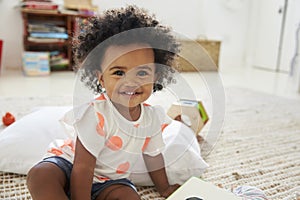 Portrait Of Happy Baby Girl Playing With Toys In Playroom