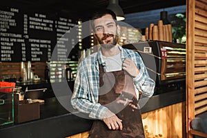 Portrait of happy barista guy working in street cafe or coffeehouse outdoor