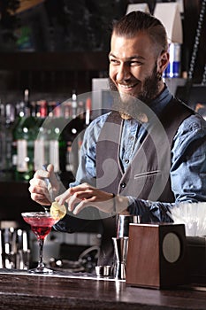 Portrait of a happy bartender making a cocktail.