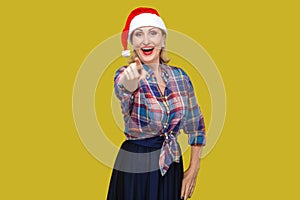 Portrait of happy beautiful adult woman in red santa cap and che