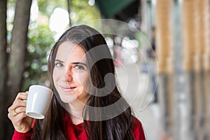 Portrait of happy beautiful brunette with mug in hand