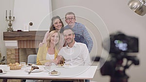 Portrait of happy beautiful family gathering and smiling at photo camera. Young redhead Caucasian man adjusting photo