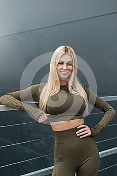 Portrait of a happy beautiful fitness girl with a smile in sportswear in the city