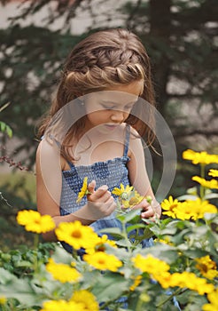 Portrait of happy beautiful girl in flowerbed