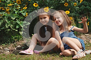 Portrait of happy beautiful girls in flowerbed