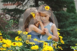 Portrait of happy beautiful girls in flowerbed