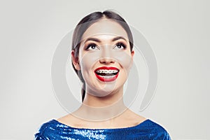 Portrait of happy beautiful woman in braces on white background. Pretty girl with braces on teeth smiling