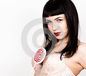 Portrait of happy beautiful young woman licking sweet candy and expressing different emotions