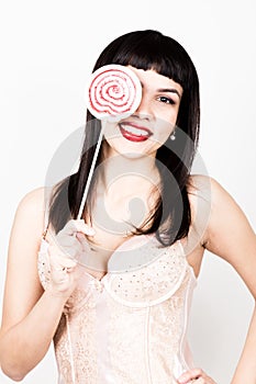 Portrait of happy beautiful young woman licking sweet candy and expressing different emotions