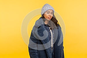 Portrait of happy beautiful young woman wearing warm winter hat and fur coat smiling, glamour fashion model