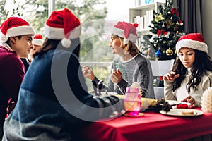 Portrait of happy big family celebrating santa hats having fun and lunch together enjoying spending time together in christmas