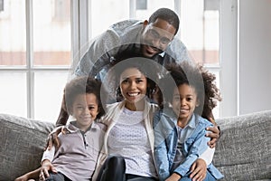Portrait of happy biracial family with kids relax at home