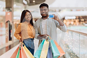 Portrait of happy black couple holding credit card